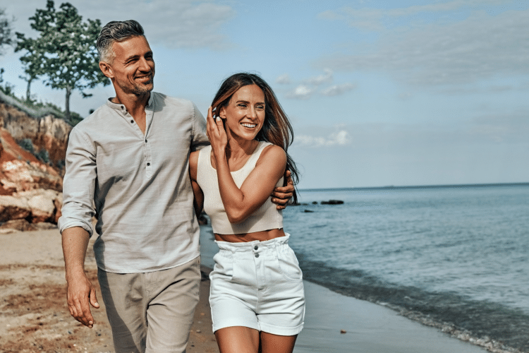 Couple walking on the beach representing Travis and Taylor’s $10M work-optional planning case study